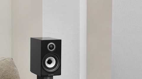 Altavoz de color negro al lado de un sofá para casa inteligente con domótica
